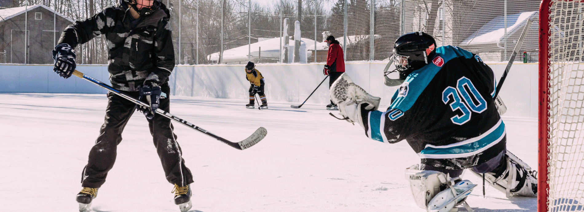 group playing hockey on an outdoor ice rink