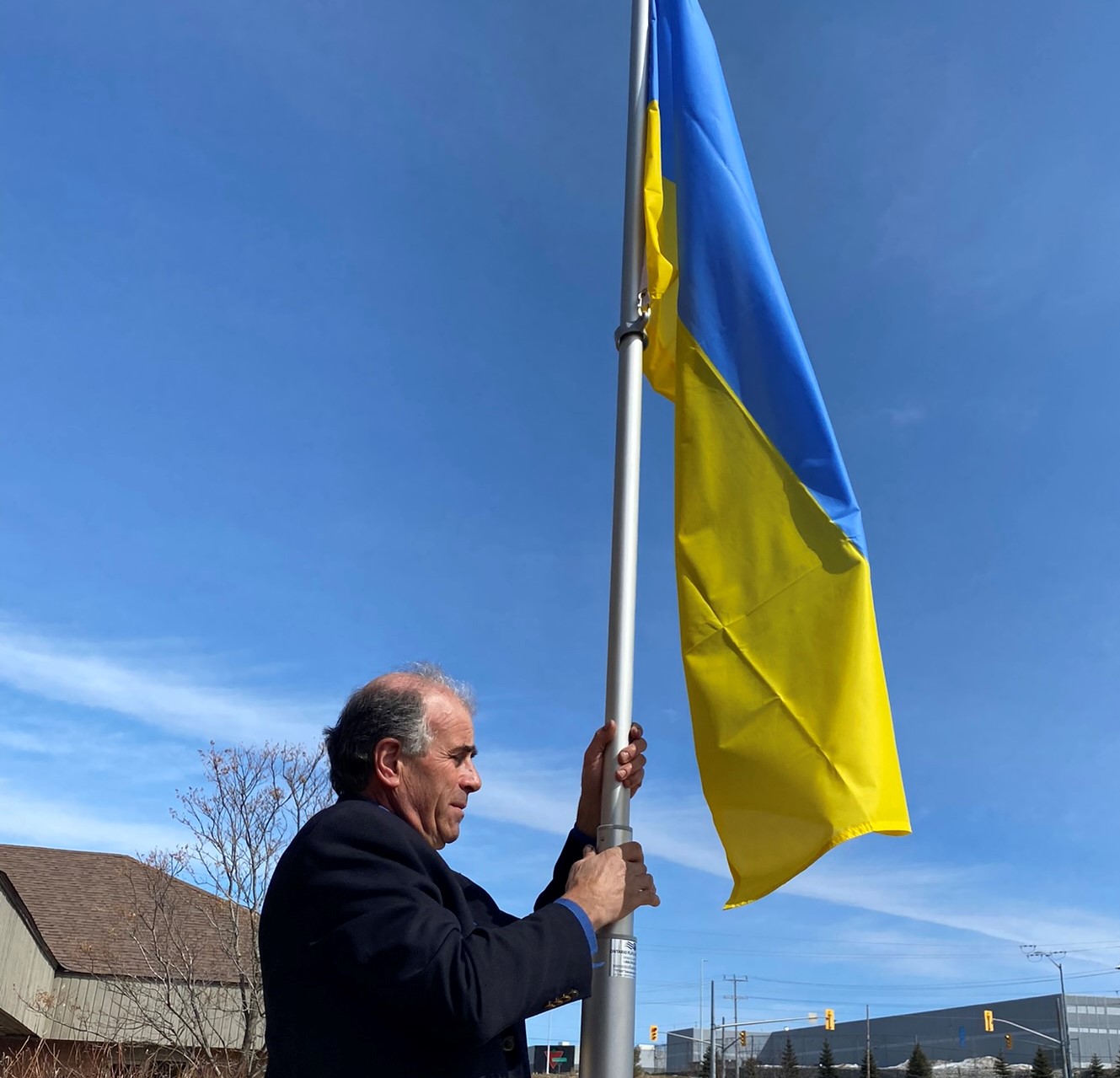 Mayor Burkett raising the Ukrainian flag at Severn's Administration Office