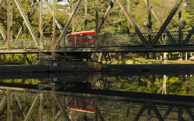 vehicle crossing a bridge over water loaded with a canoe