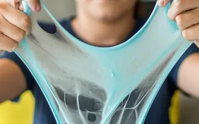 child holding green slime in their two hands