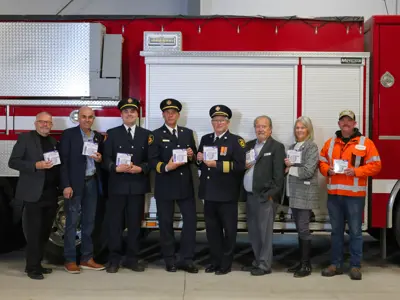 Members of Council and Severn Fire and Emergency Services standing in front of a fire truck holding the smoke and carbon monoxide alarms